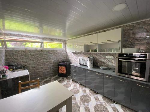 una cocina con armarios grises y una mesa. en NINO, en Kobuleti