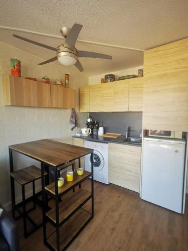 une cuisine avec une table et un ventilateur de plafond dans l'établissement Studio 4 personnes, au Grau-du-Roi