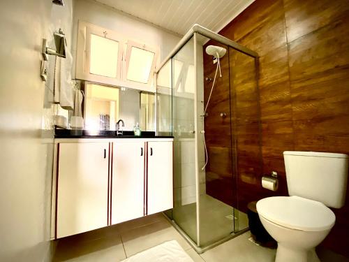 La salle de bains est pourvue de toilettes, d'une douche et d'un lavabo. dans l'établissement 242 Casa da Praia em Condomínio Frente Mar, à Aracaju