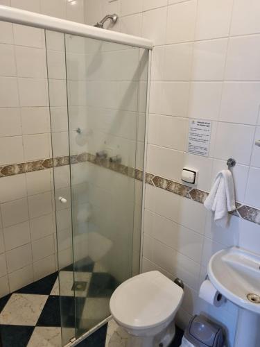a bathroom with a shower and a toilet and a sink at Camping Pousada Ilha do Mel - Frente ao Mar in Boracéia