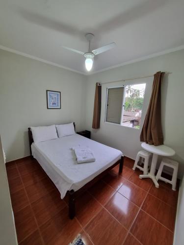 a bedroom with a white bed and a window at Camping Pousada Ilha do Mel - Frente ao Mar in Boracéia