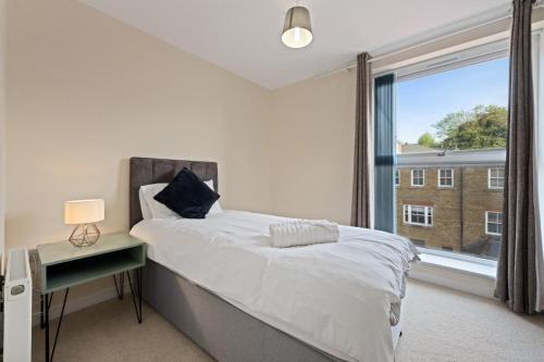 a bedroom with a bed and a large window at High Wycombe Short Stay Apartment in High Wycombe