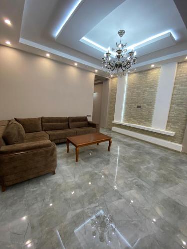 a living room with a couch and a table at Buzovna Delmar Luxury Residence in Baku