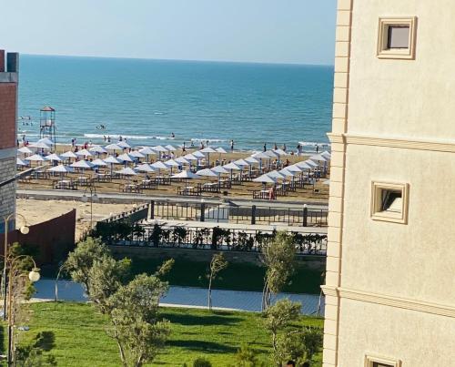 a view of a beach with umbrellas and the ocean at Buzovna Delmar Luxury Residence in Baku