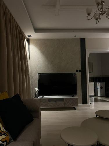 a living room with a large flat screen tv at شقه غرفه وصاله مودرن مع دخول ذاتي in Riyadh