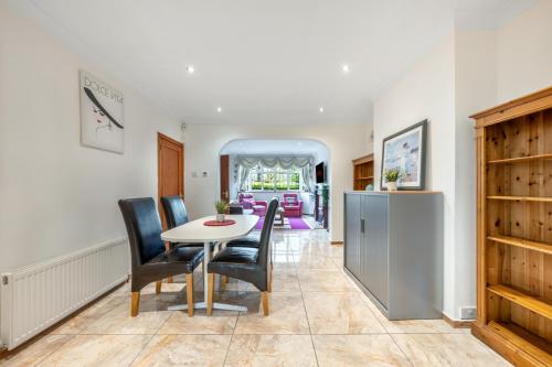 a kitchen and dining room with a table and chairs at Barnet Serviced Accommodation - Elegant 5-Bedroom Home, Just a 7-Minute Stroll from High Barnet Station - Book Your Stay Today!" in New Barnet
