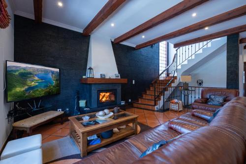 a living room with a couch and a fireplace at Azores Palmeira Villa in Ponta Delgada