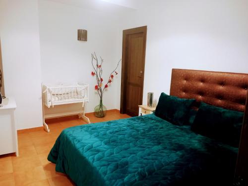 a bedroom with a bed with a green comforter at Apartamento Valentino's- Alpujarra in Carataunas