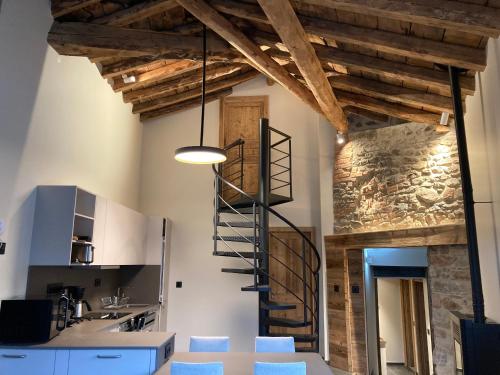a spiral staircase in a kitchen with blue chairs at Les Fermes de Cal Panche : Le Cabanat in Les Angles