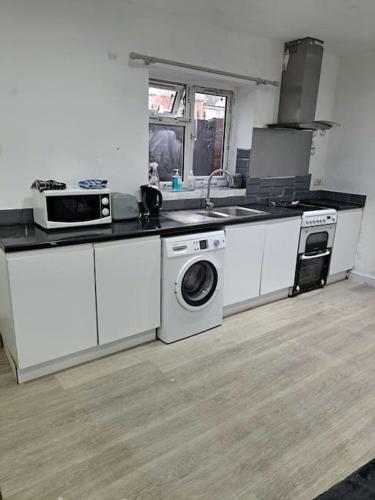 a kitchen with a sink and a washing machine at 2 Bed apt 1 kitchen 1 Bath in Birmingham