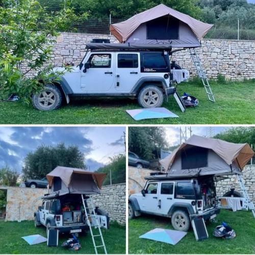 a white jeep with a tent on top of it at Cortina House Berat in Kuçovë