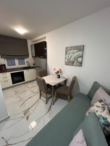 a living room with a table and a kitchen at Apartments Mare in Punat