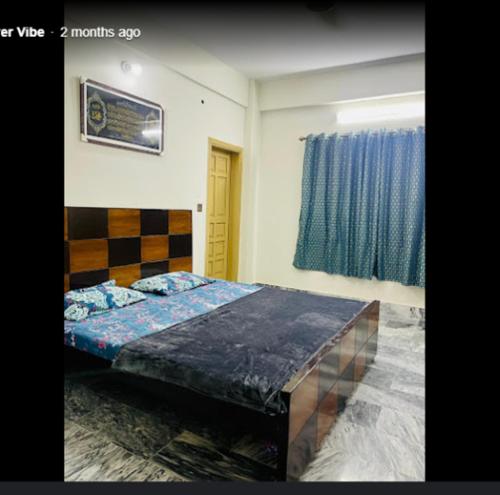 a bedroom with a bed and a blue curtain at River Vibes Guest House in Muzaffarabad
