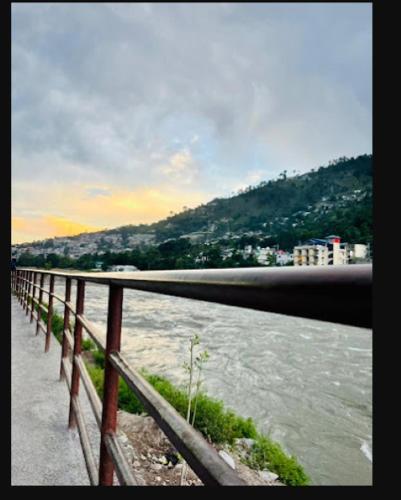 a fence next to a body of water at River Vibes Guest House in Muzaffarabad