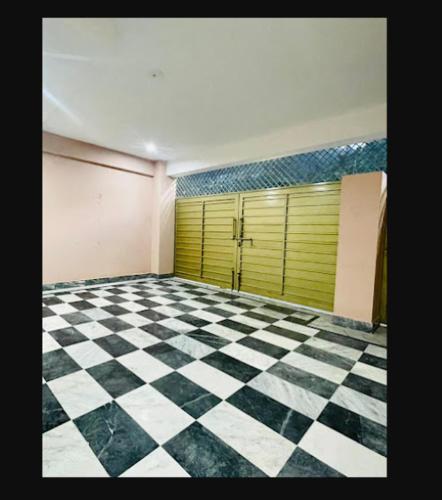 an empty room with a checkered floor and yellow doors at River Vibes Guest House in Muzaffarabad