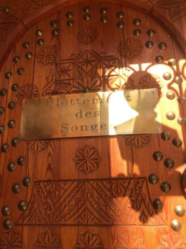 un reflet d'un signe sur une table en bois dans l'établissement Flottement Des Songes, à Marrakech