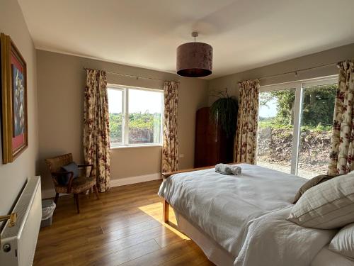 a bedroom with a bed and a large window at The Lodge, Monkstown in Monkstown