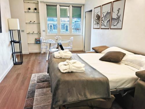 2 Betten in einem Zimmer mit Tisch und Stühlen in der Unterkunft Spa Apartment in centro in Genua