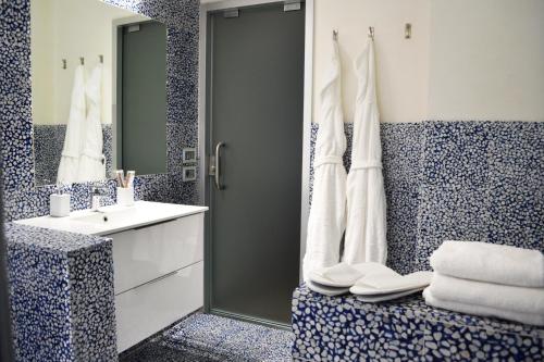 ein blau-weißes Bad mit einem Waschbecken und einem Spiegel in der Unterkunft Spa Apartment in centro in Genua