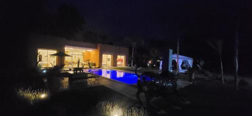 a house with a swimming pool at night at Le jardin de Jeanne in Marrakech