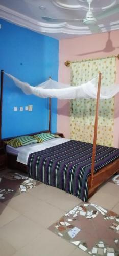 a bedroom with a bed with a mosquito net at CHEZ ALFA in Djougou