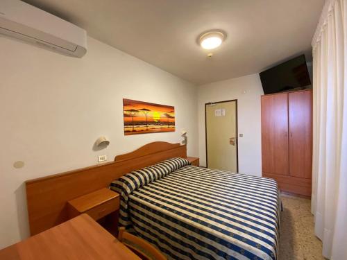 a bedroom with a bed and a table in it at Hotel Erika in Caorle