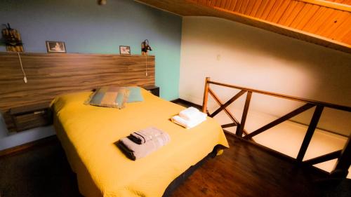 Un dormitorio con una cama amarilla con toallas. en Terrazas del sur en Ushuaia
