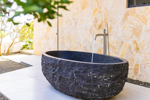 a large black stone tub sitting on top of a table at Luxury 12-Guest Villa in Gated Community with Pool, Ocean View & Private Beach Access in Willibrordus