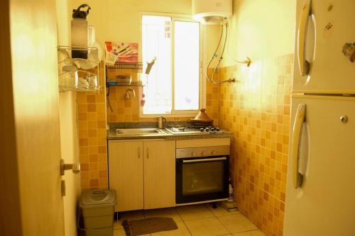 Elle comprend une petite cuisine avec un évier et une fenêtre. dans l'établissement Room in Agadir Morocco, à Agadir