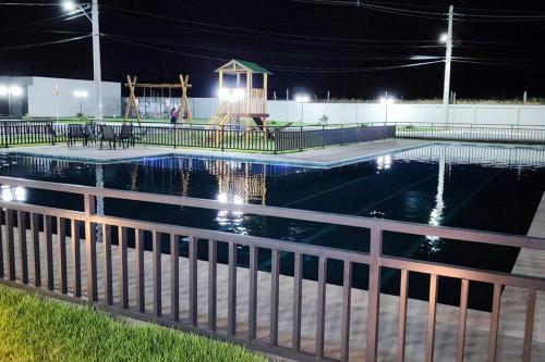 a swimming pool at night with a playground at Casa Aconchegante B in Guanamby