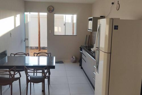 a kitchen and dining room with a table and a refrigerator at Casa Aconchegante B in Guanamby