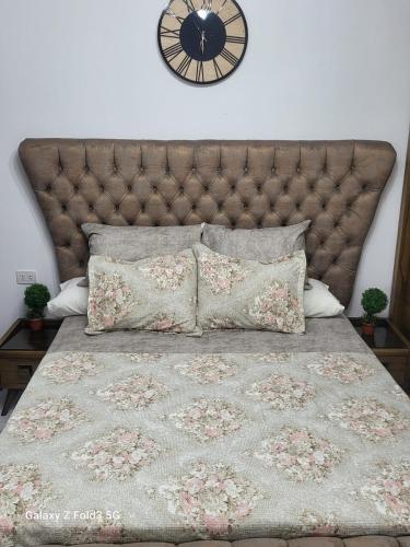 شالية غرفة ورسيبشن وحمام ومطبخ أرضي بجاردن خاص في بورسعيد: سرير مع اللوح الأمامي كبير وساعة على الحائط