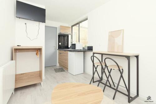 une cuisine avec un comptoir, une table et des chaises dans l'établissement La résidence Jeanne d'Arc 2, Troyes - France, à Troyes