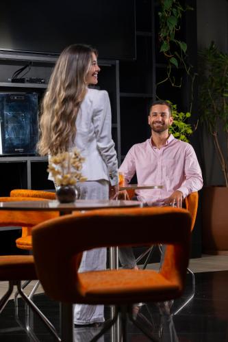 a woman and a man sitting at a table at Novotel RJ Praia de Botafogo in Rio de Janeiro