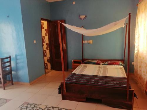 a bedroom with a bed with a canopy at CHEZ ALFA in Jugu