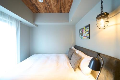a bedroom with a bed and a light fixture at Hotel Resol Akihabara in Tokyo