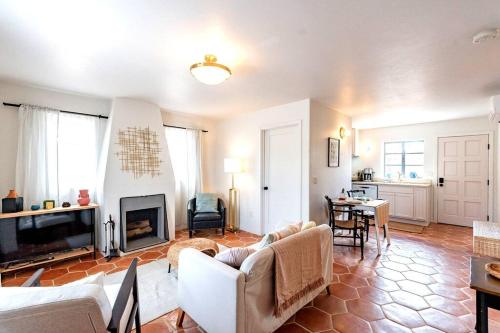 a living room with white furniture and a fireplace at Cute & Cozy 2BR 1BA Adobe w Firepit Near UA & UMC in Tucson