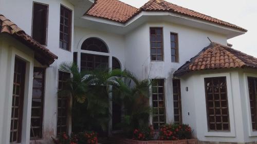 Casa blanca con techo de baldosa en Beautiful House Colombia, en Burrero