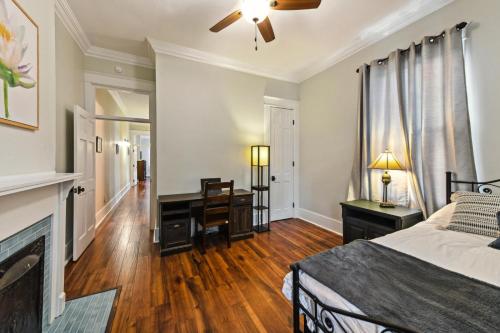 a bedroom with a bed and a desk and a fireplace at Stunning Uptown 3 Bedroom 3 Bathroom home in New Orleans