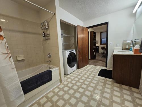 ein Badezimmer mit einer Badewanne und einer Waschmaschine in der Unterkunft City Hall Clerk's Office in Rochester