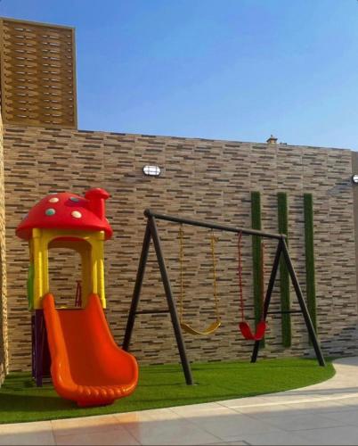 a playground with a swing and a swing at شاليهات واتر وولد in Raʼs Munaysif