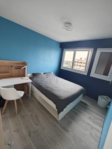 - une chambre bleue avec un lit, un bureau et une chaise dans l'établissement Chambre Poitiers, à Poitiers