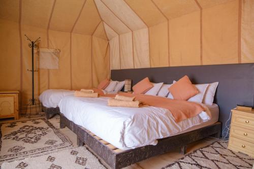 a bedroom with a large bed in a tent at Merzouga Luxury Tent in Merzouga