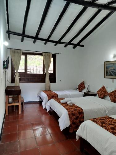 a room with three beds and a piano at Hotel MAXIRUMA - Villa TAMAUKA in Iza