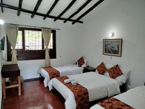 a hotel room with three beds and a window at Hotel MAXIRUMA - Villa TAMAUKA in Iza