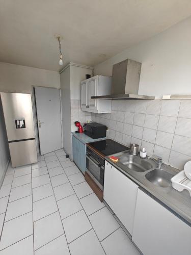 une cuisine avec un évier et un réfrigérateur dans l'établissement Chambre Poitiers, à Poitiers