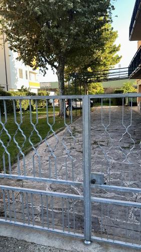 une clôture à maillons avec un arbre derrière elle dans l'établissement B&B Francesco, à Pise