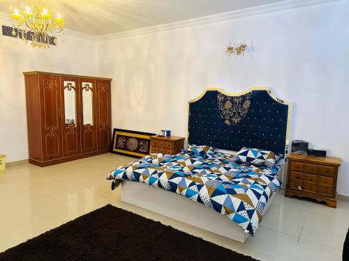 a bedroom with a bed with a blue and white comforter at Tranquil Haven King Bed Ensuite Fully Furnished Bedroom in Ajman 