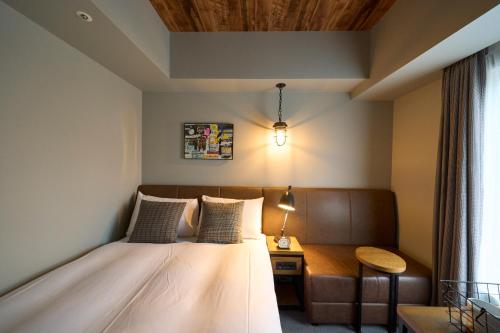 a bedroom with a bed and a table and a lamp at Hotel Resol Akihabara in Tokyo