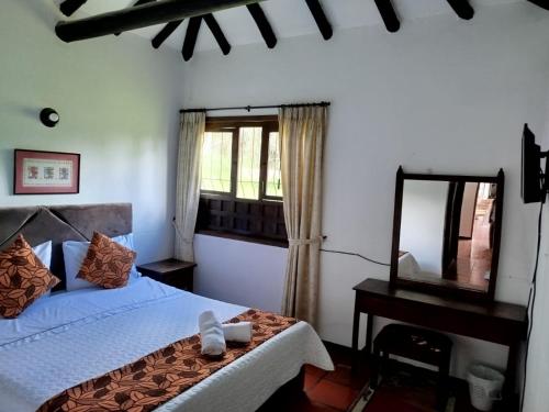 a bedroom with a bed and a table and a mirror at Hotel MAXIRUMA - Villa TAMAUKA in Iza